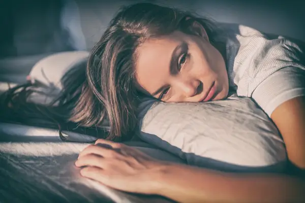 Tired woman lying in bed can