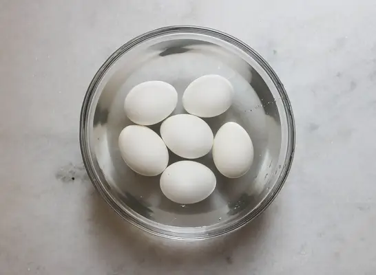 Eggs in cold water before peeling in a bowl