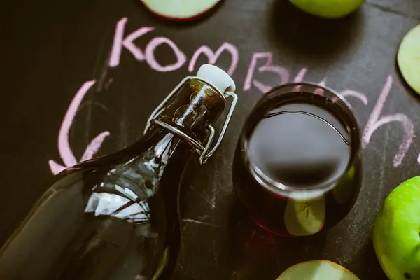 kombucha bottle next to glass