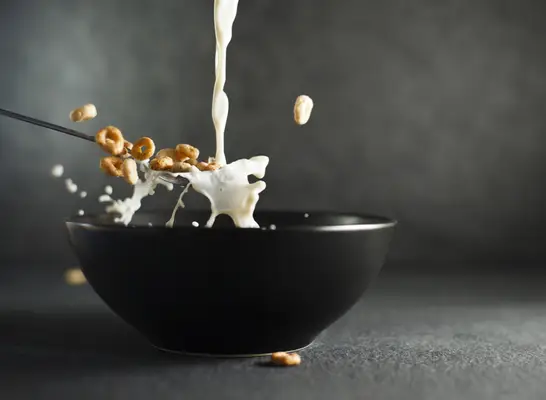 milk pouring into cereal bowl