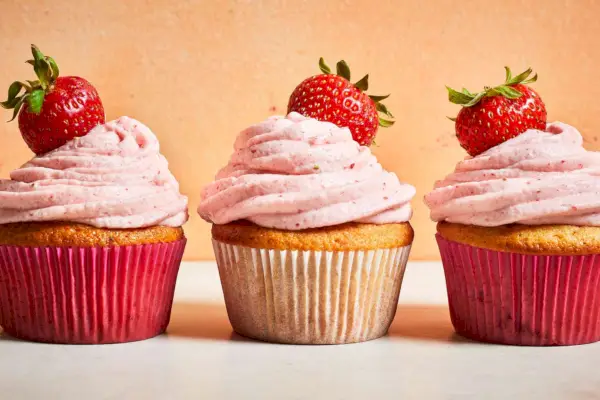 tres cupcakes de fresa con glaseado de queso crema