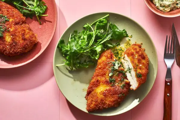 Zwei Teller Kiewer Hühnchen serviert mit grünem Salat