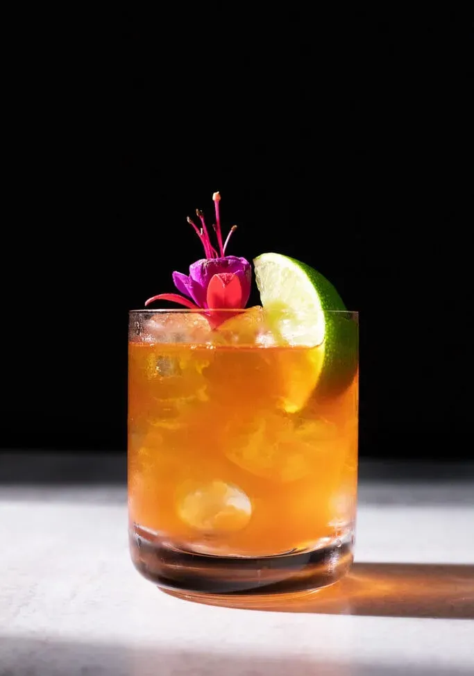 cocktail di mais e olio con un fiore commestibile rosa.' loading='lazy' title=
