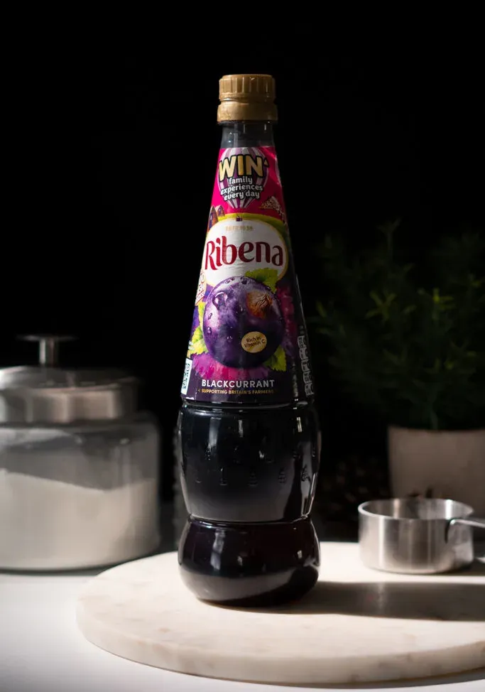 bottiglia di plastica alta di succo di ribes nero Ribena su pietra di marmo bianco.' loading='lazy' title=
