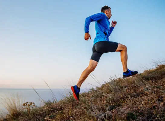 man running uphill, concept of how to build endurance for longer runs