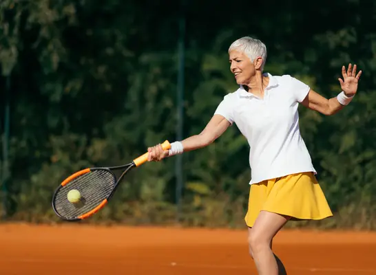 mature woman playing tennis, worst exercises for arthritis