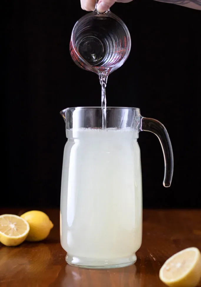 레모네이드를 만들기 위해 투수에 물을 붓습니다.' title=