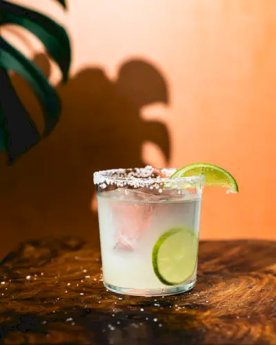 Coquetel de tequila em copo com rodela de limão e borda de sal.