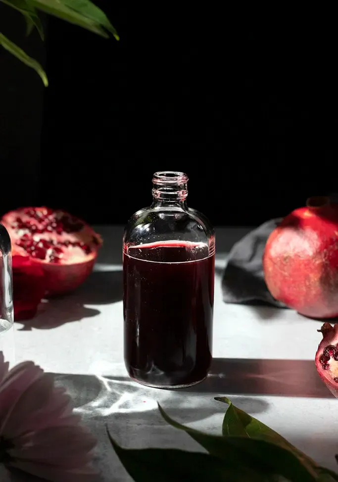eine Apothekerflasche, gefüllt mit dunkelrotem Sirup' loading='lazy' title=