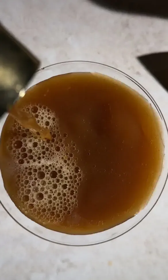 nalewając brązowy koktajl espresso do szklanki.' loading='lazy' title=