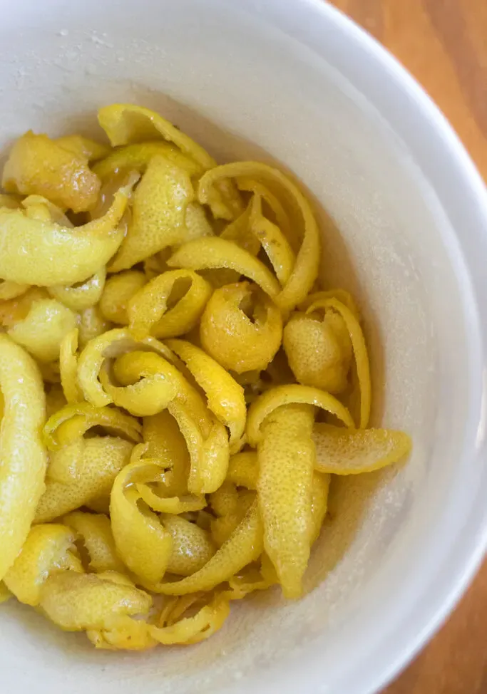 le bucce di limone e lo zucchero in una ciotola.' loading='lazy' title=