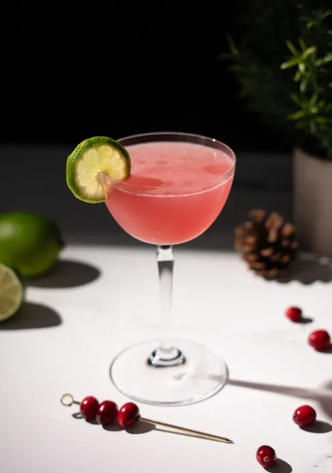 un cocktail rosso con una fetta di lime sul bordo.' loading='lazy' title=