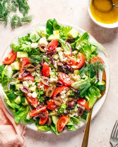 Mediterraner Salat auf Teller mit Dressing.