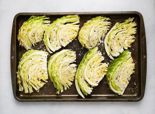 cooked cabbage wedges on a baking sheet
