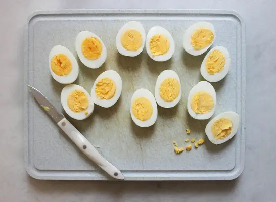 eggs peeled and cut up on a cutting board