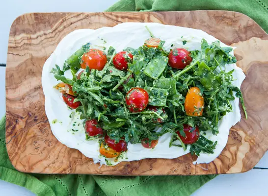 ricotta tomato arugula salad on wooden board with green dish towel healthy with nedi