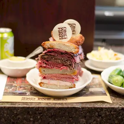 Ein halbiertes und aufgespießtes Triple Bypass-Sandwich im 2nd Avenue Deli
