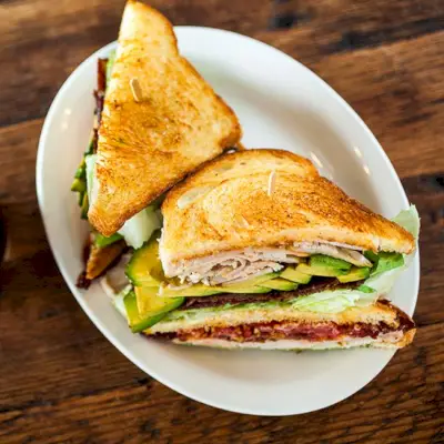 Ein halbiertes Sandwich mit Truthahn und Avocado bei Wise Sons Jewish Delicatessen