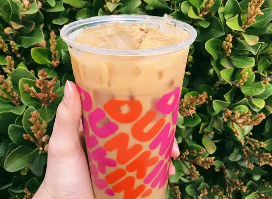 hand holding cup of Dunkin