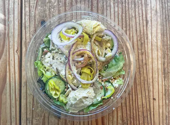 The new Mediterranean Chicken Greens with Grains from Panera Bread on a wooden table