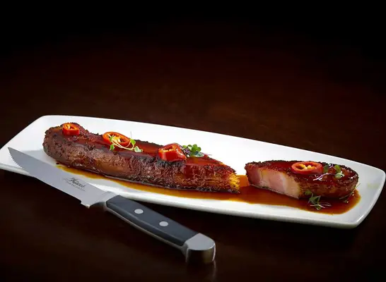 Thick Cut Bacon Au Poivre served in bourbon molasses glaze at Del Frisco