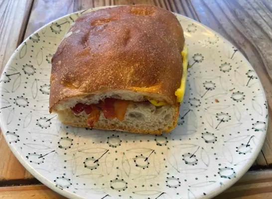 panera bacon egg and cheese on ciabatta sandwich on printed plate.