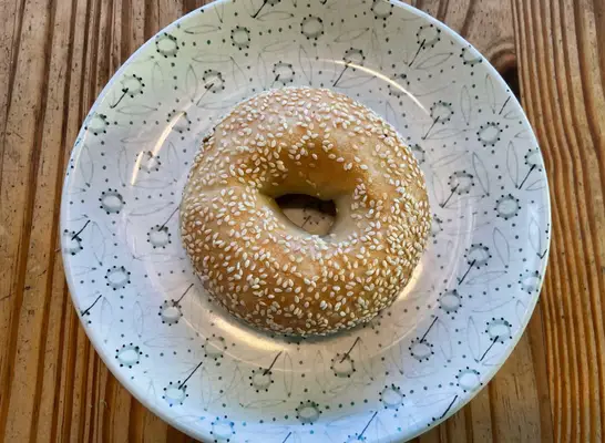 a panera sesame bagle on a printed plate.