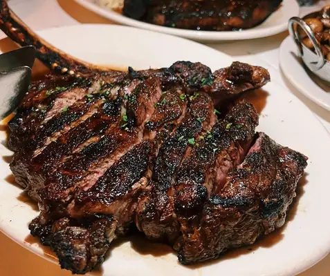 Bone-in ribeye sliced and neatly plated at Morton