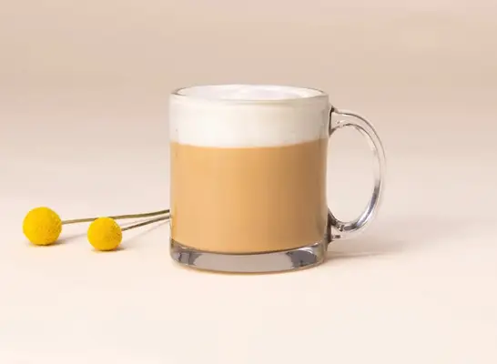 starbucks nitro sweet cream cold brew in a glass on a green background.