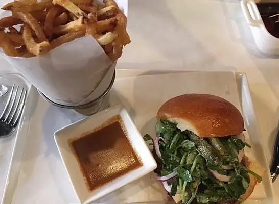 Burger from La Lucha atop a yellow wrapper