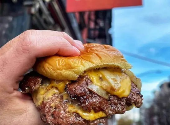 The famous burger at Au Cheval in Chicago, served open faced with a fried egg and pickle