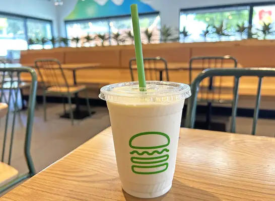 A vanilla milkshake in a see-through cup from Shake Shack