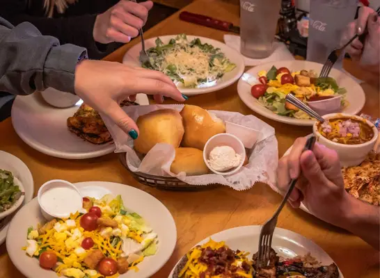 people sitting at table full of food