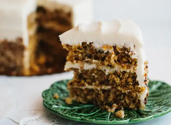 A slice of carrot cake on a green plate at Muddy