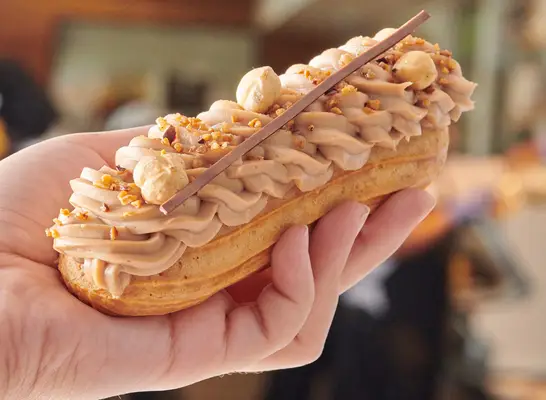 A chocolate hazelnut Éclair held aloft at Porto