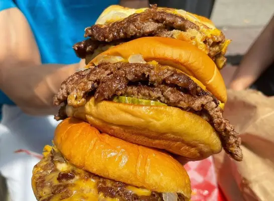 person holding bugers from 7th street burger
