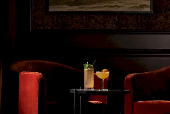 Malý odkládací stolek se dvěma koktejly v klubu Founders v hotelu Fairmont Olympic