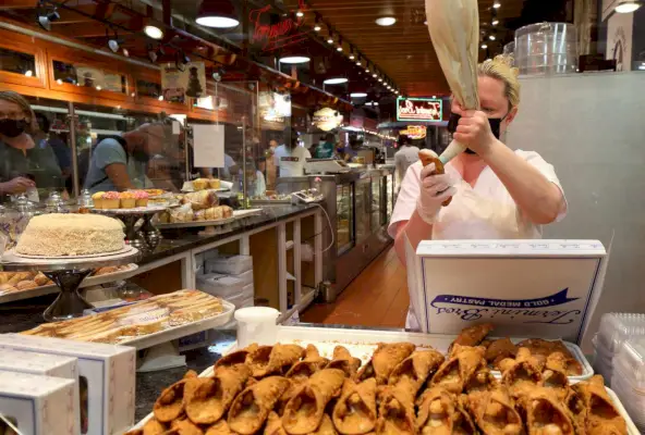 Žena plniaca cannolis v pekárni Termini Brothers v Reading Terminal Market