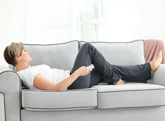 woman on couch sedentary lifestyle concept