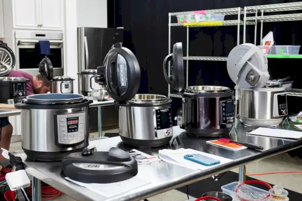 Quatro panelas elétricas em uma mesa, incluindo Panela de Pressão Instant Pot 6-Quart Max 9 em 1