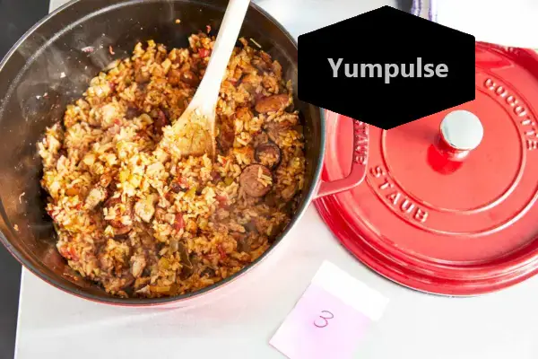 Miska na ryžu a drevená lyžica vo vnútri Staub 5,5-Quart Round Cocotte na pulte