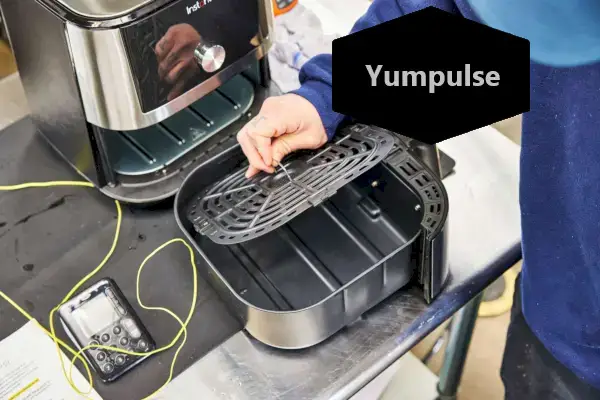 Staub 5,5-Quart Round Cocotte vystavený na stole v blízkosti paradajok, cesnaku a korenia