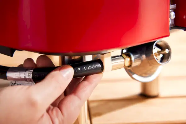 Mão segurando a churrasqueira portátil a gás Cuisinart Venture
