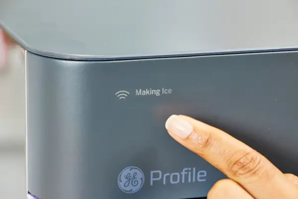 Una persona señala una luz en la máquina de hielo en pepitas para encimera GE Profile Opal 2.0 con tanque lateral