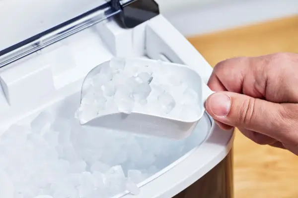 Una persona saca hielo de la máquina de hielo Nugget de encimera AGLucky