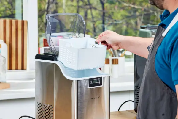 Una persona ensambla la máquina de hielo Frigidaire Countertop Nugget Ice Maker V2