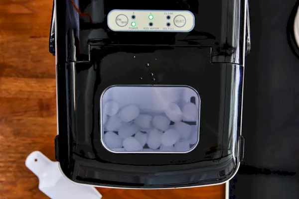 Máquina de hielo para encimera Silonn junto a una jarra y vasos