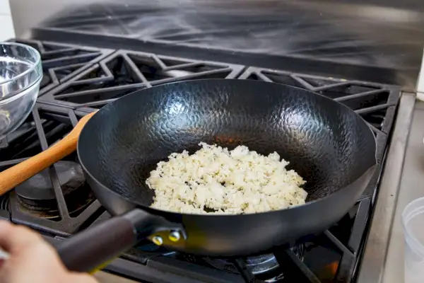 Osoba gotująca jedzenie w woku ze stali węglowej Souped Up Recipes