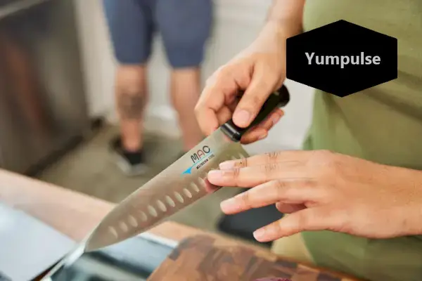 יד ימין אוחזת ב-Mac Knife 8-Inch Hollow Edge Chef