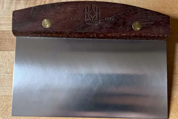Un gros plan du couteau d'établi King Arthur Baking Company sur une planche à découper
